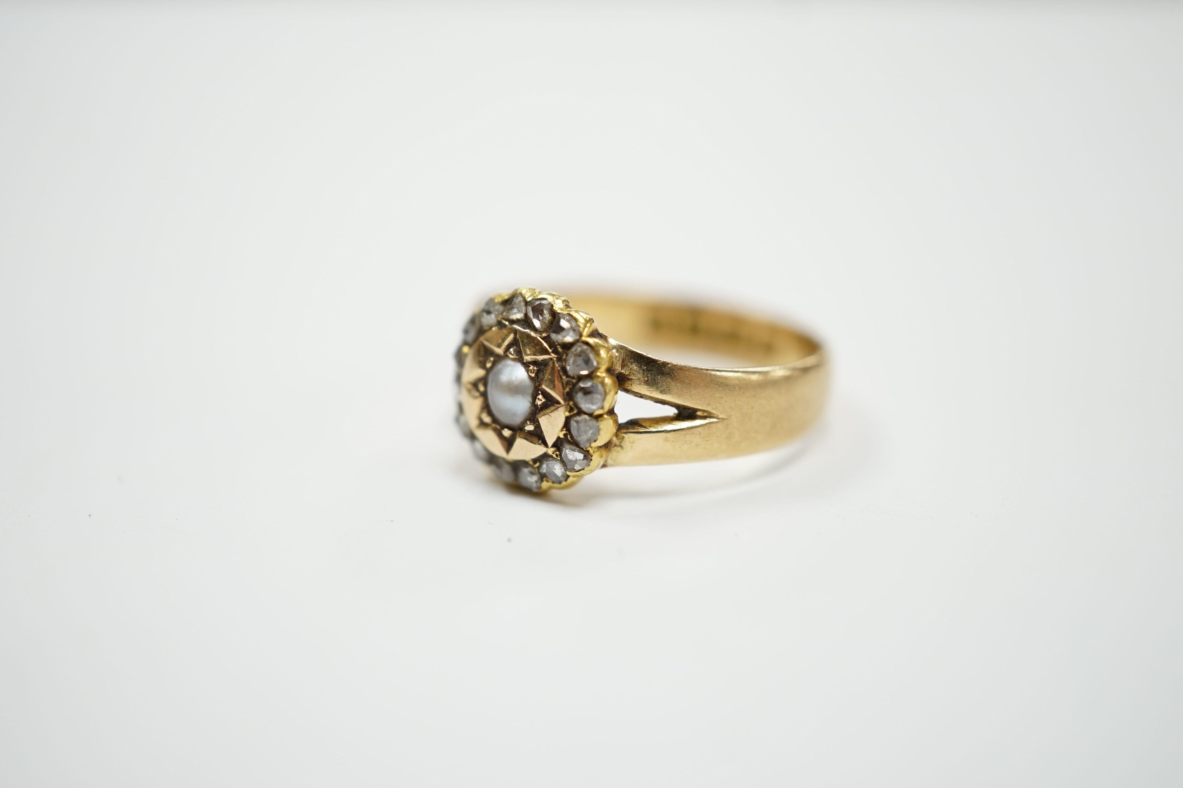 An Edwardian 18ct gold, rose cut diamond and split pearl cluster set ring, size O, gross weight 3.2 grams.